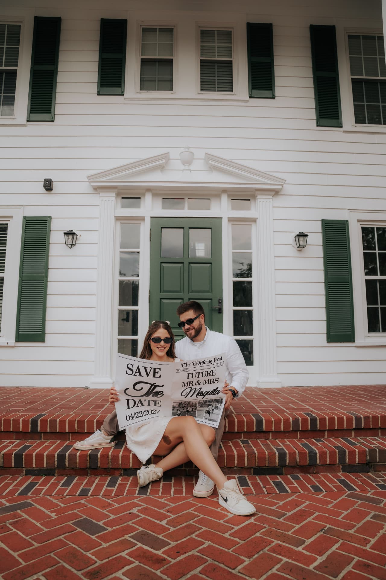 Jenni e Pedro com o jornal Save the Date diante da casa branca